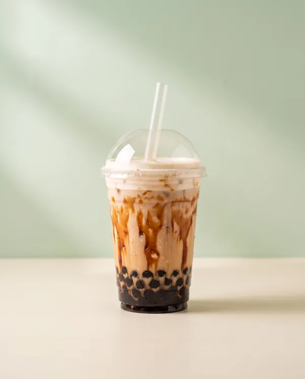 Black sugar milk tea with cream foam and tapioca pearls in a clear cup