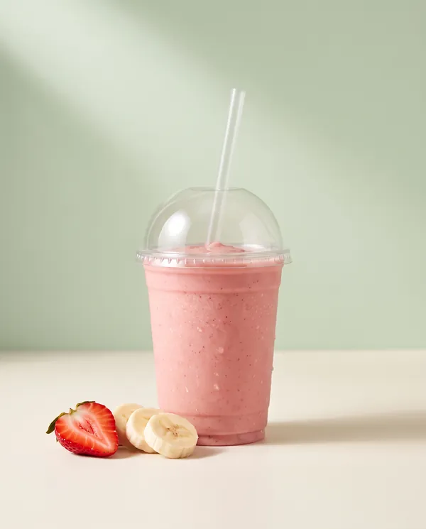 Strawberry banana smoothie with a halved strawberry and banana slices